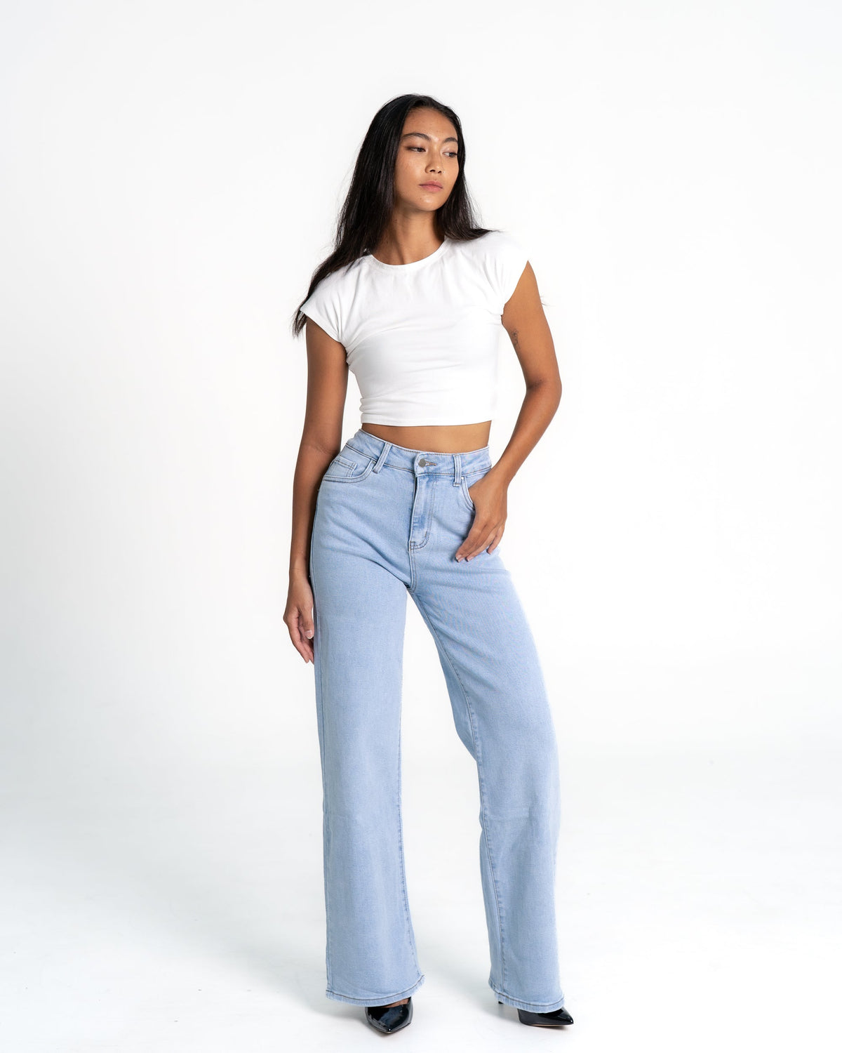 Woman wearing stretchy light wash wide leg jeans that fit at the waist