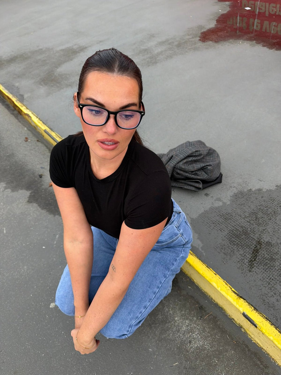 Model in light wash wide leg jeans and black tee